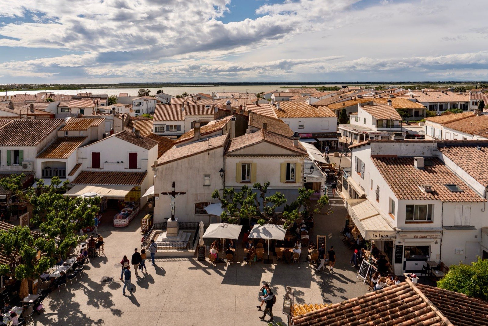 Vue aérienne d’un village français, place centrale et rues autour de l’église.